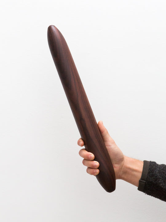 holding a thick rosewood rolling pin