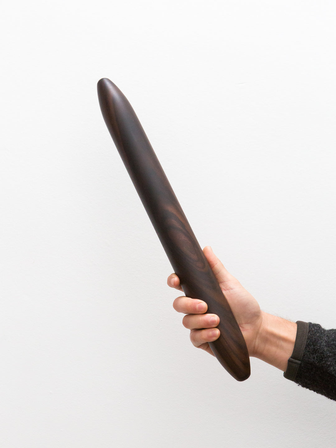 a dark brown rosewood rolling pin